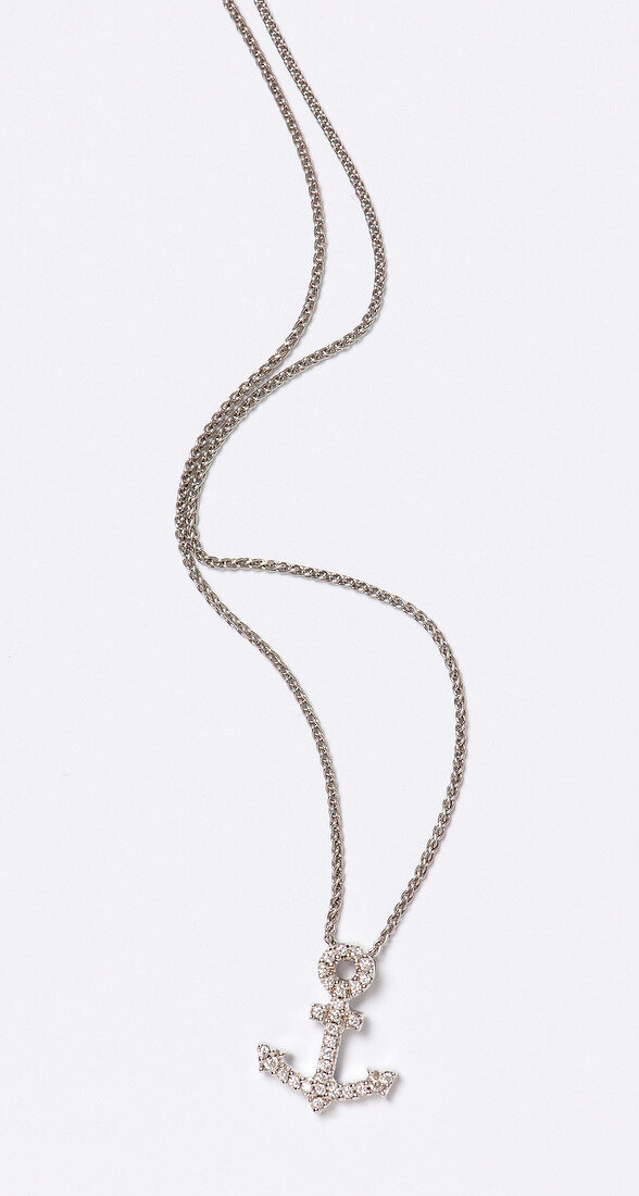 Close-up of white gold necklace with diamonds on white background
