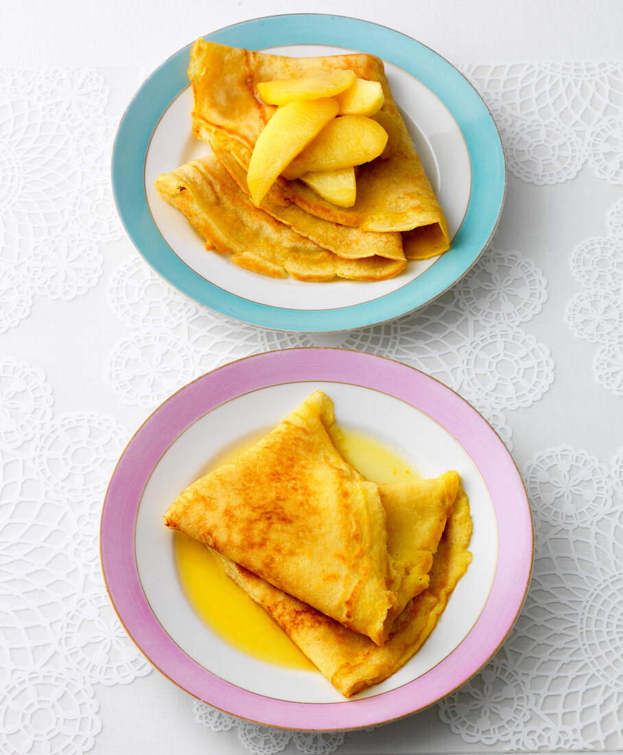 Two plates of crepes with calvados apples and crepes suzette