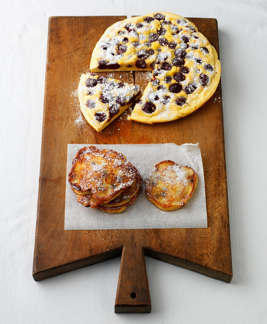 Cherry pancakes and raisins quark pancakes with icing sugar on serving board