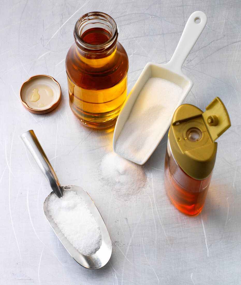 Different types of sweeteners bottles and salt in scoop