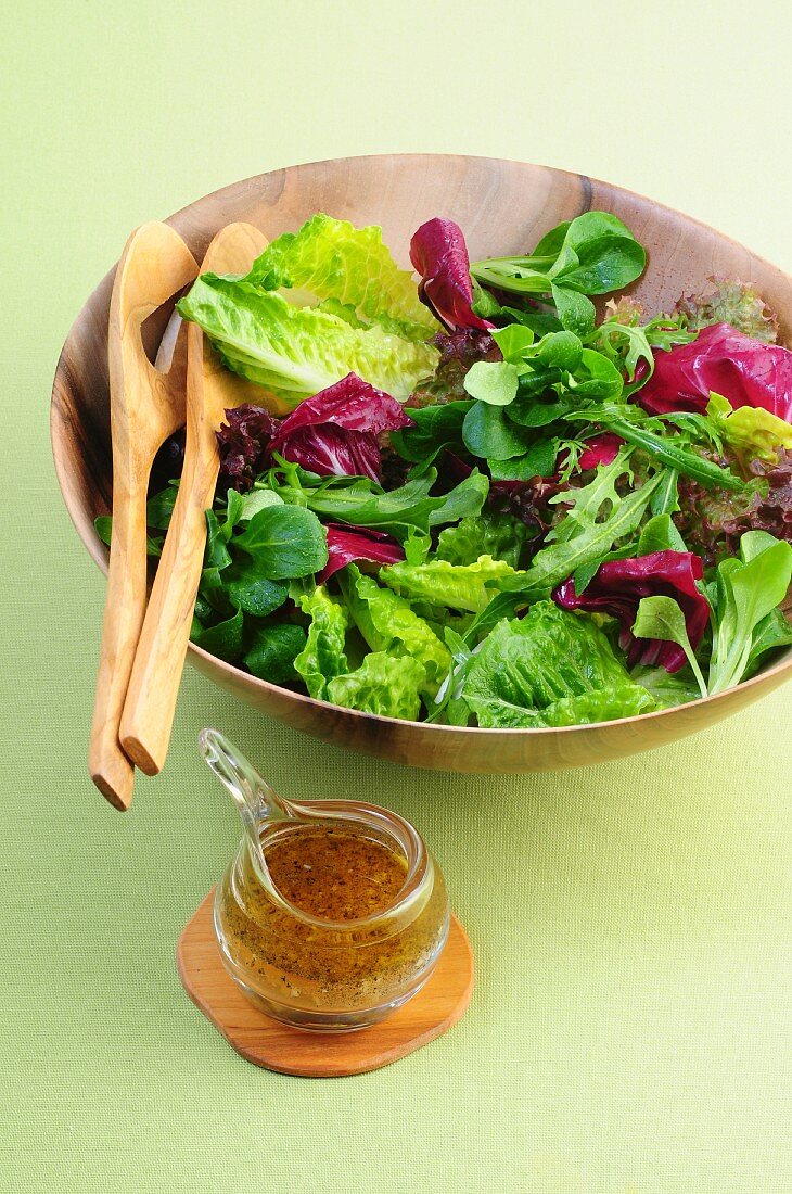 Gemischter Blattsalat in Holzschüssel mit Dressing