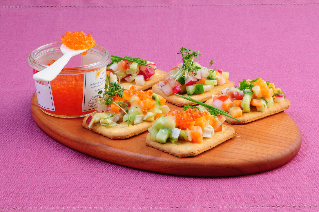 Vegetable tarts with caviar on chopping board