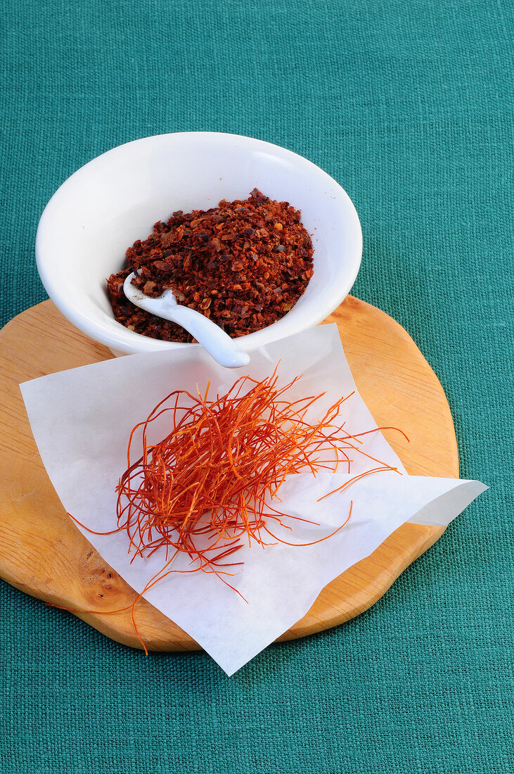 Aleppo pepper in bowl with saffron on paper