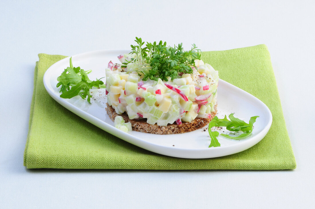 Radish salad with cress on whole meal bread on tray