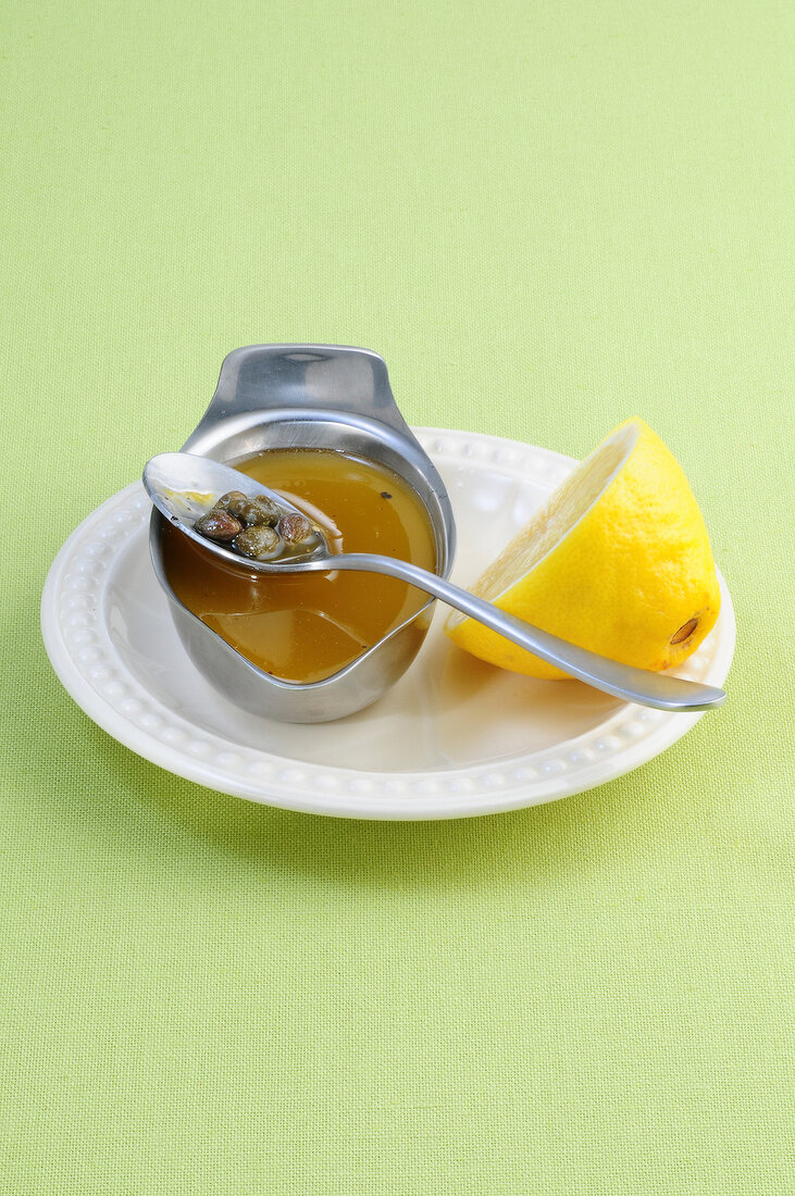 Capers in oil with lemon on plate