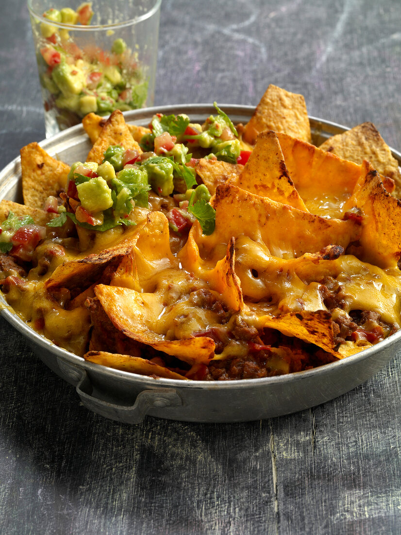 Close-up of nachos with beef and avocado salsa in pan