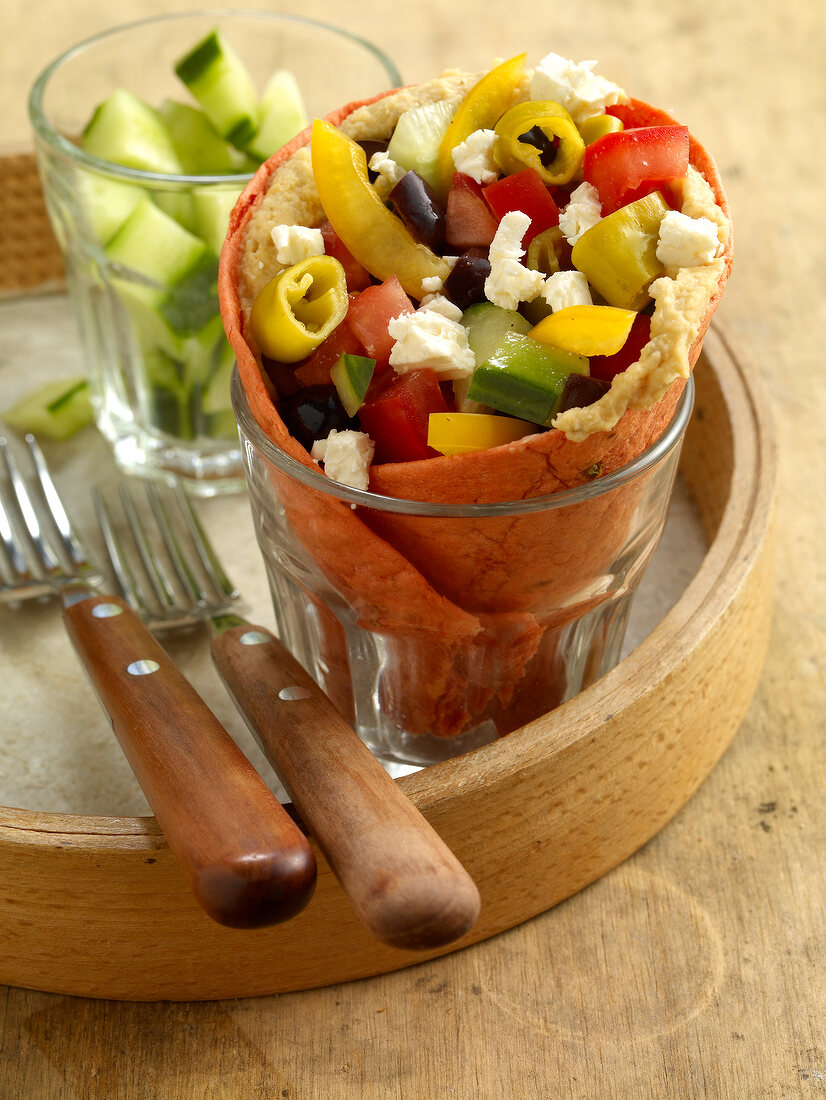 Close-up of wraps with Greek peasant salad in glass