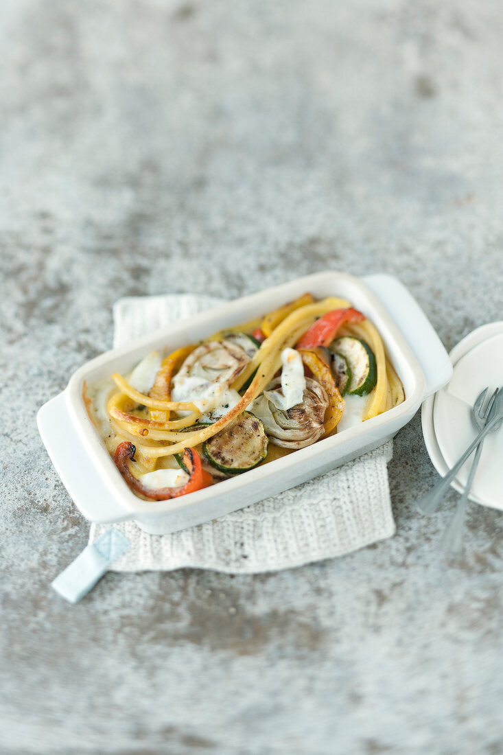 Macaroni gratin with grilled vegetables on serving dish