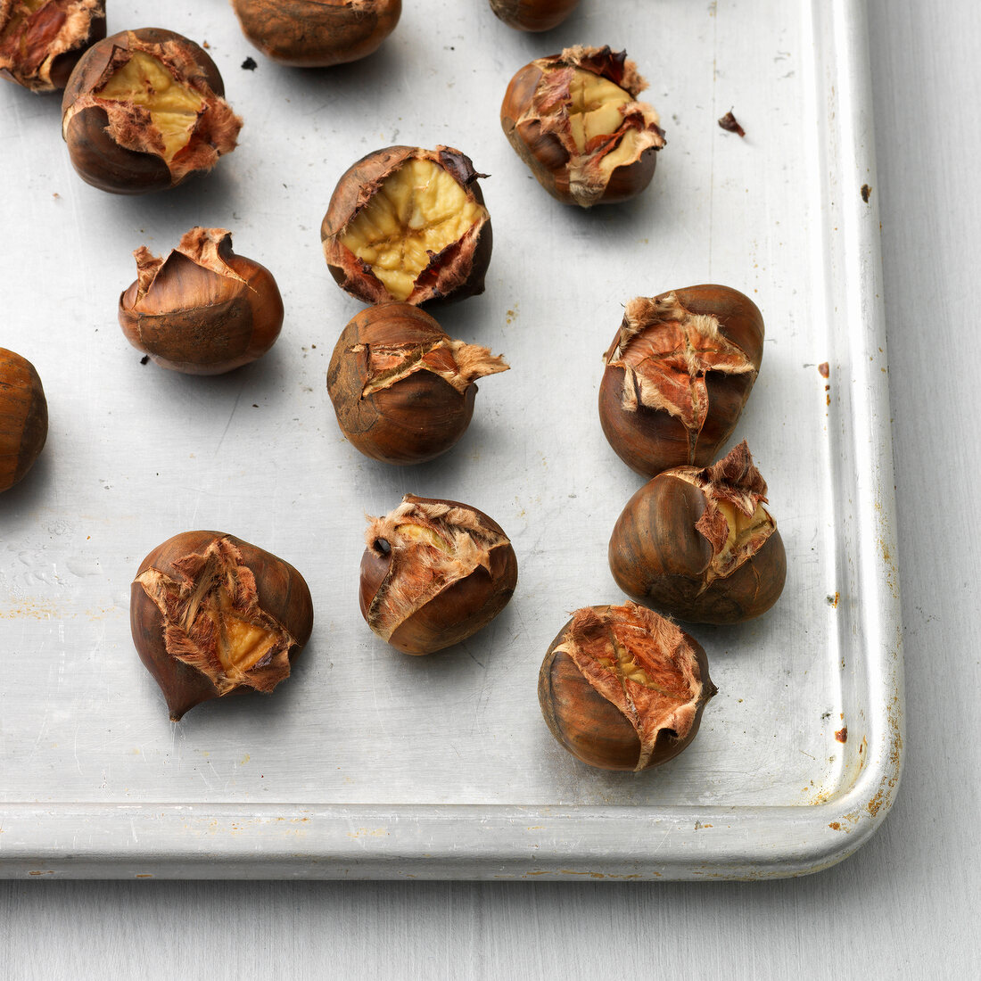 Roasted chestnuts with shells on baking tray