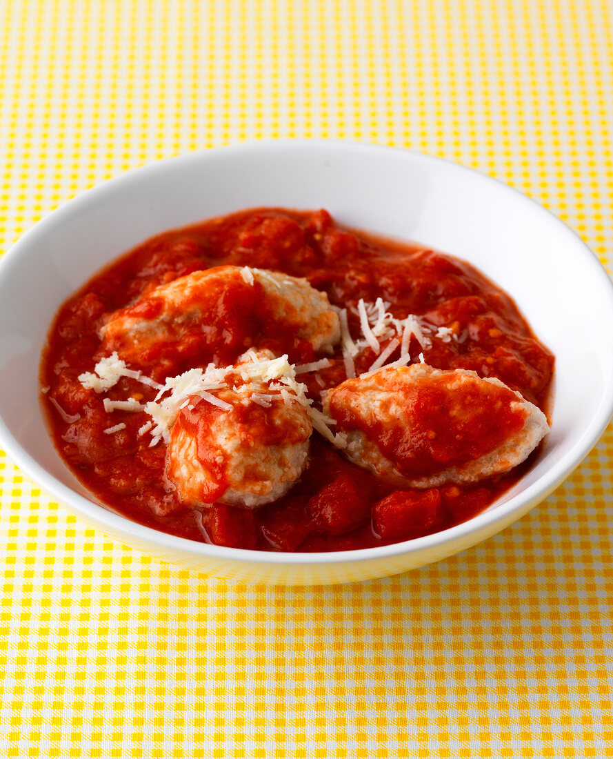 Bowl of semolina dumplings in tomato sauce 