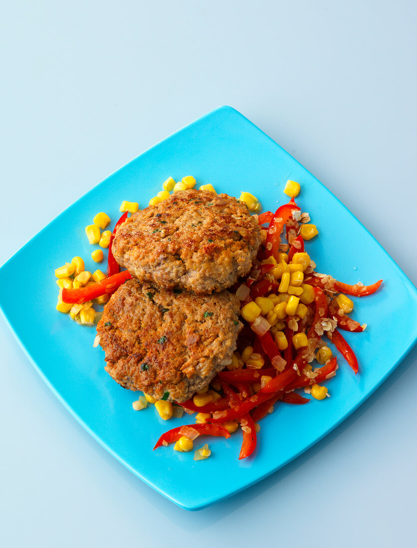 Meatballs with corn and sliced red pepper on plate