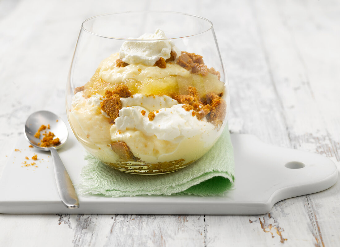 Pudding with stewed fruit, cookies and cream in glass