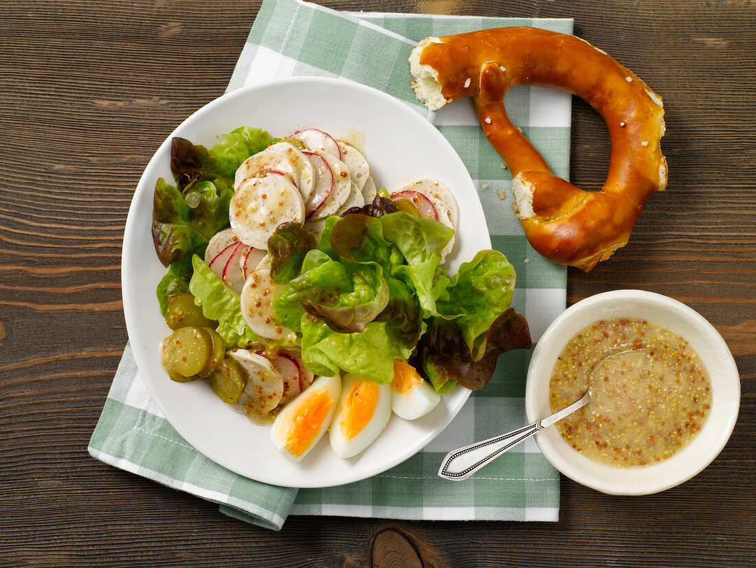 White sausage salad with mustard dressing on plate