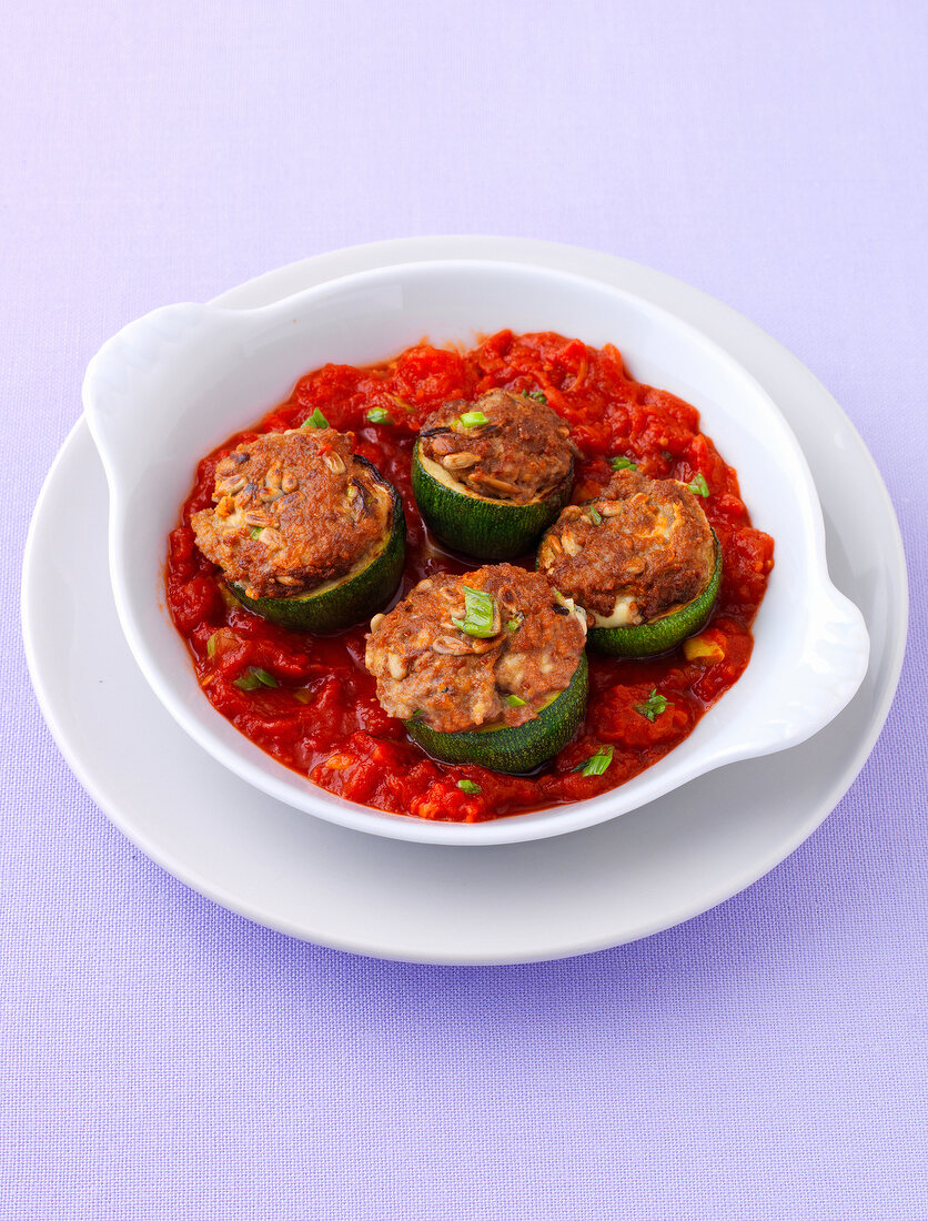 Bowl of stuffed patty with tomato sauce on plate