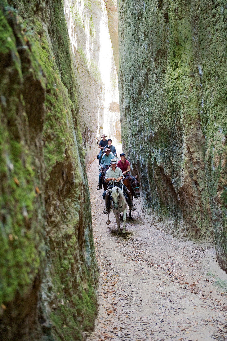 Italien, Toskana, Maremma, Reiter durchqueren eine künstliche Schlucht