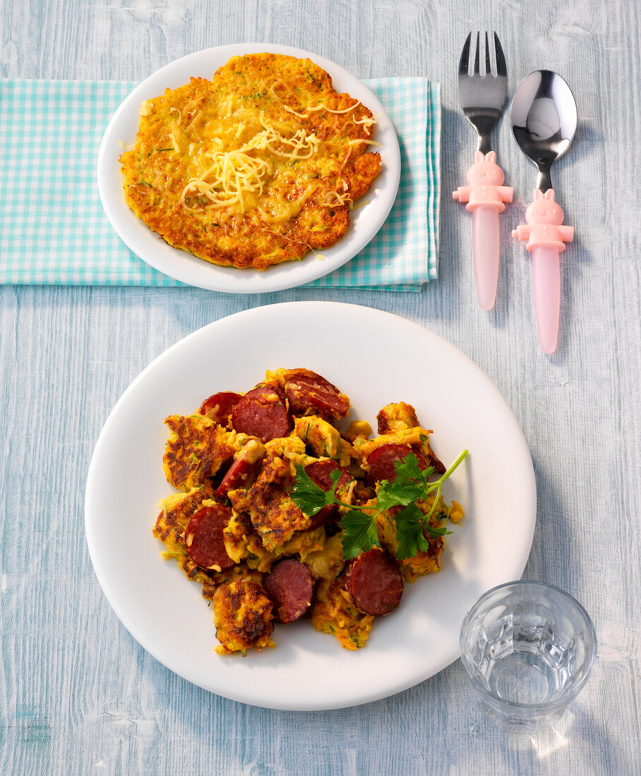 Vegetable pancakes and gemuseschmarren with sausage on plates