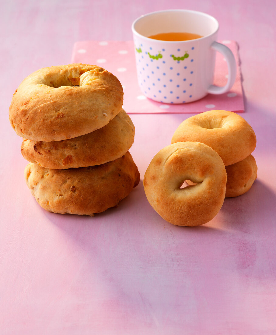 Mini bagels and bagel with cereal on pink background
