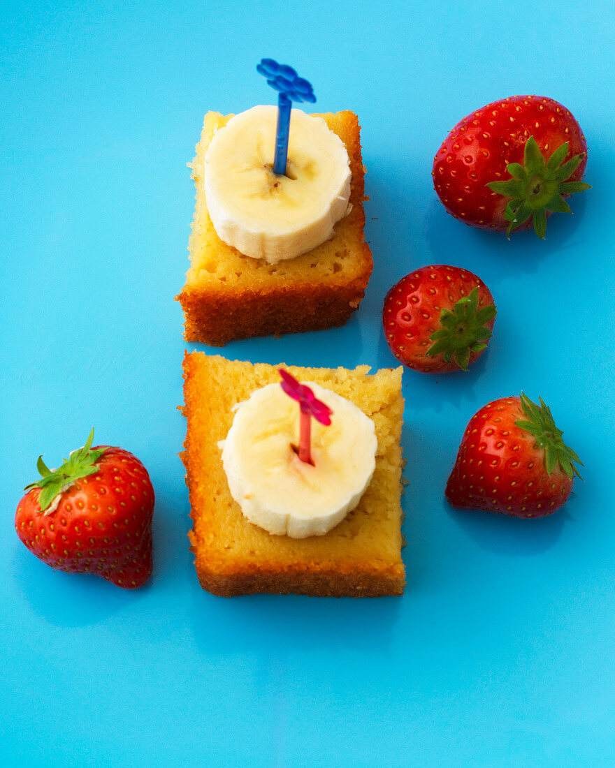 Close-up of apple sauce cake with colourful cake sticks and strawberries