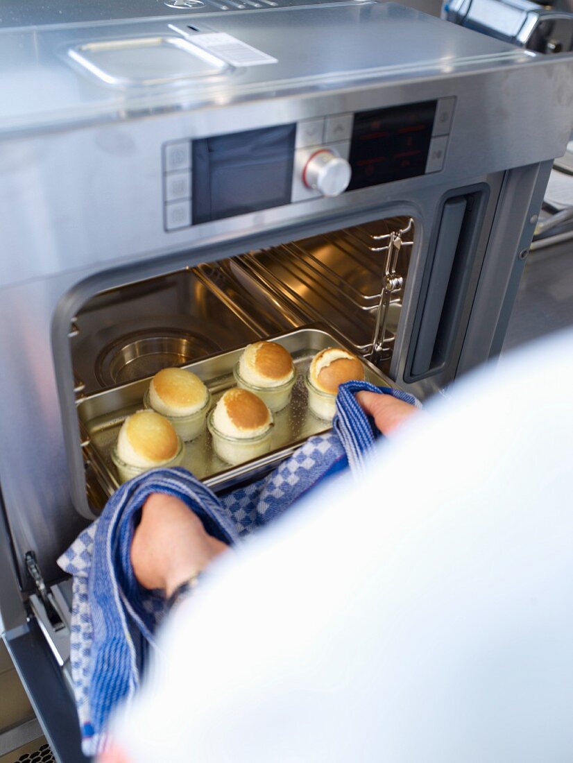 Small soufflés being removed from a steam oven