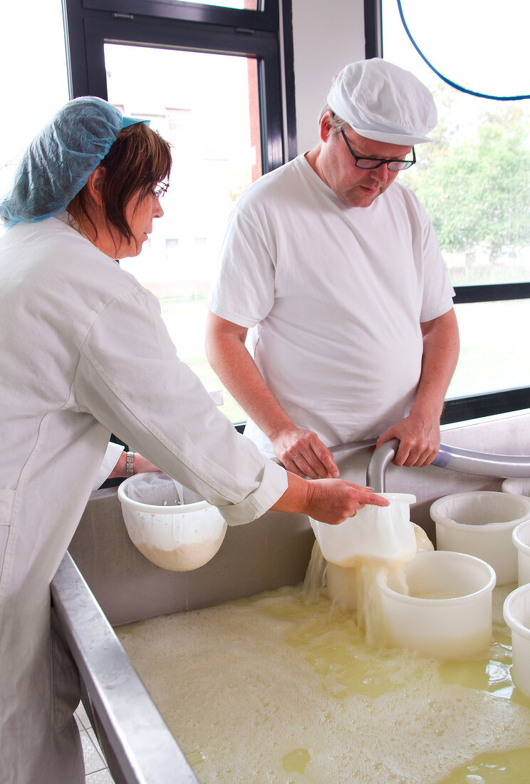 Man and Women preparing cheese in cheese containers and bags