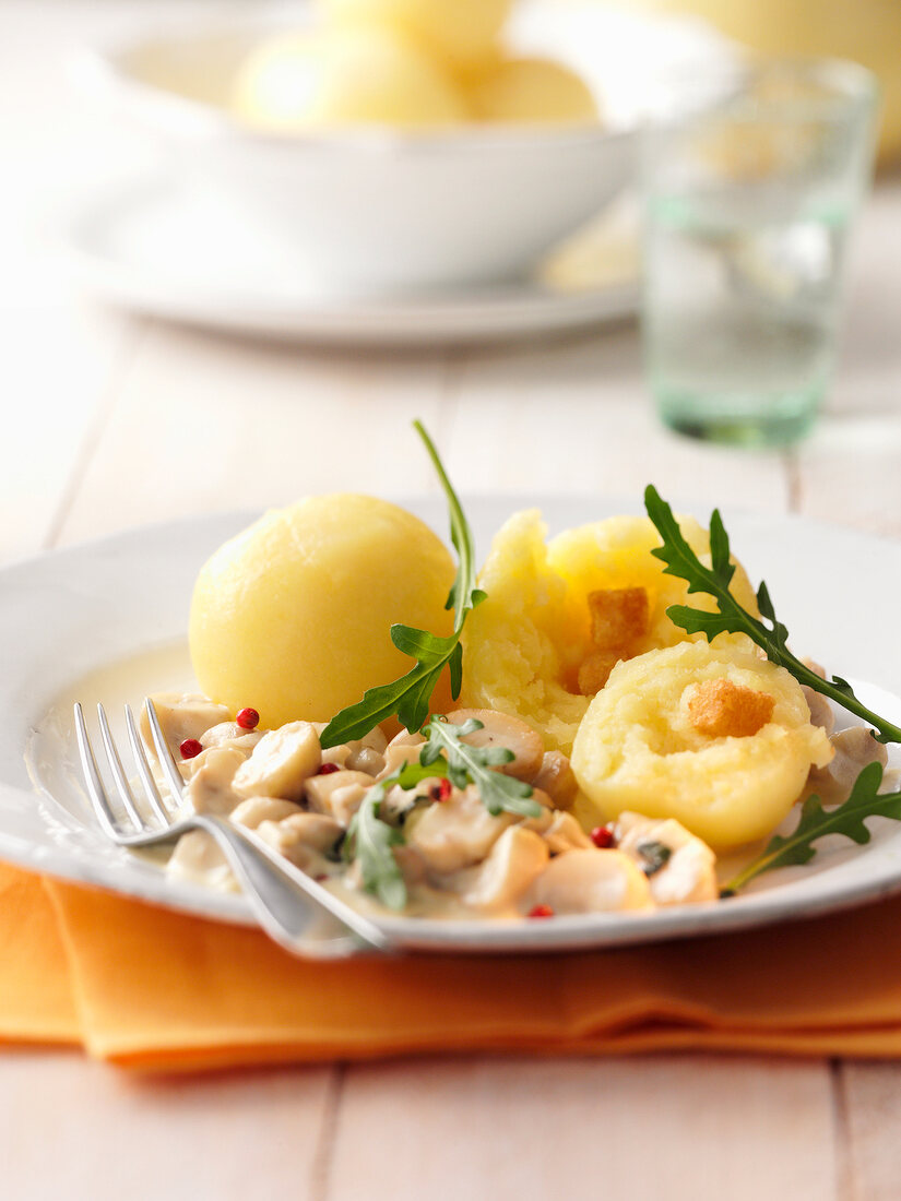 Potato dumplings with mushrooms and arugula herb on plate