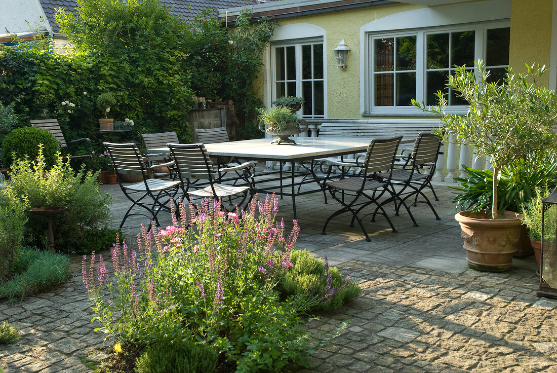 Paved patio with dining in garden outside home