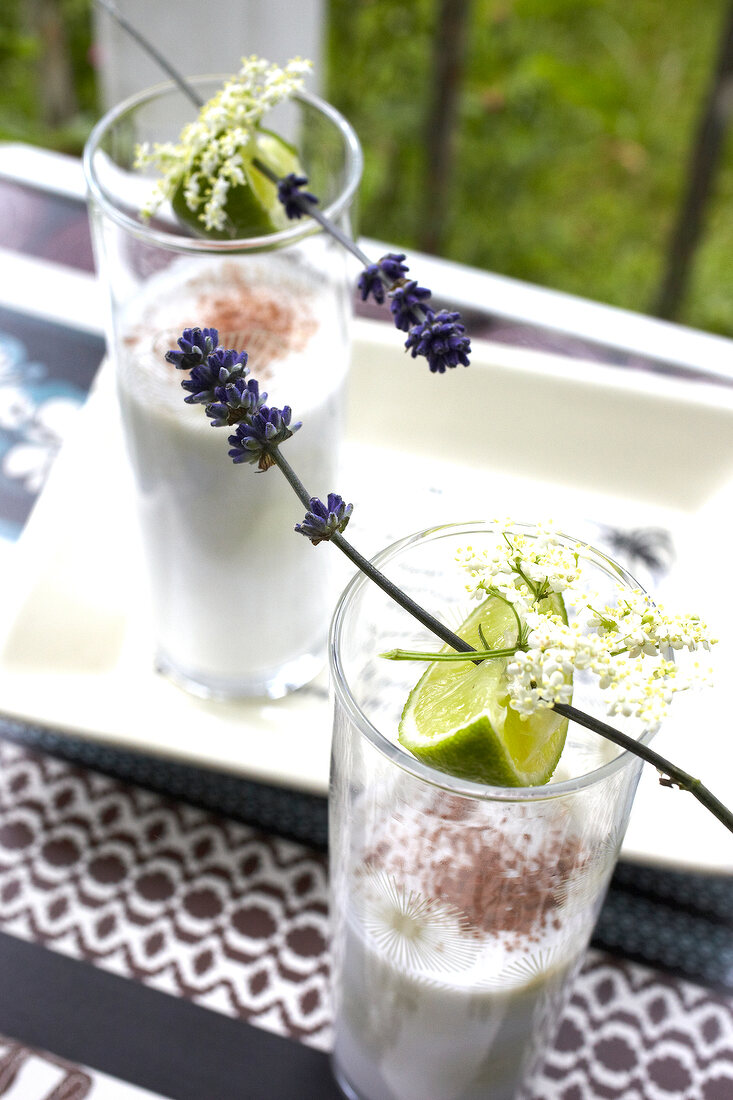 Coconut drink garnished with lavender and lime in glasses
