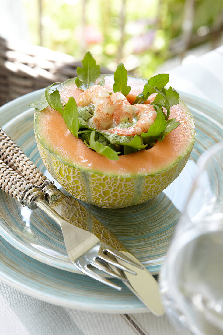 Cantaloupe melon stuffed with prawns and vegetable on plate