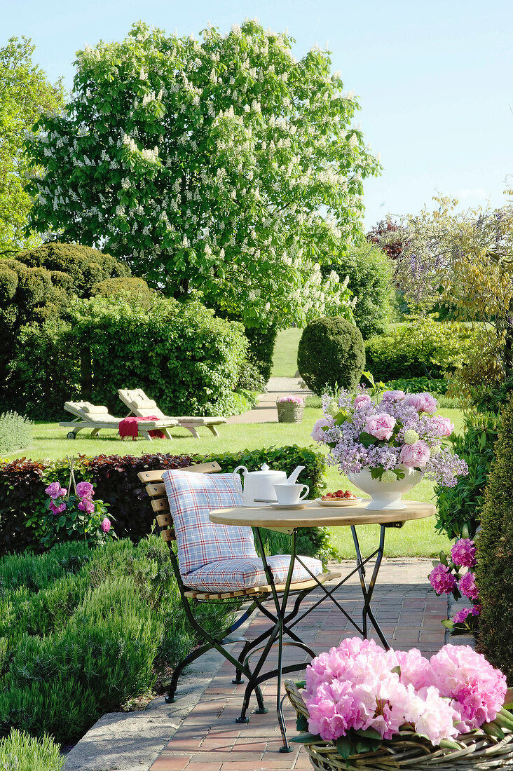 View of garden terrace with patio and folding furniture on lawn