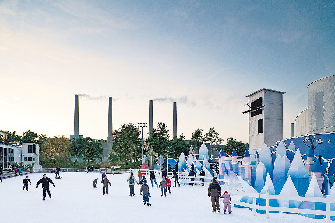View of people ice skating overlooking chimneys in Wolfsburg, Germany