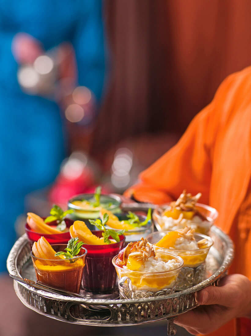 Close-up of spice rice with dates, peach and almond cream in bowls