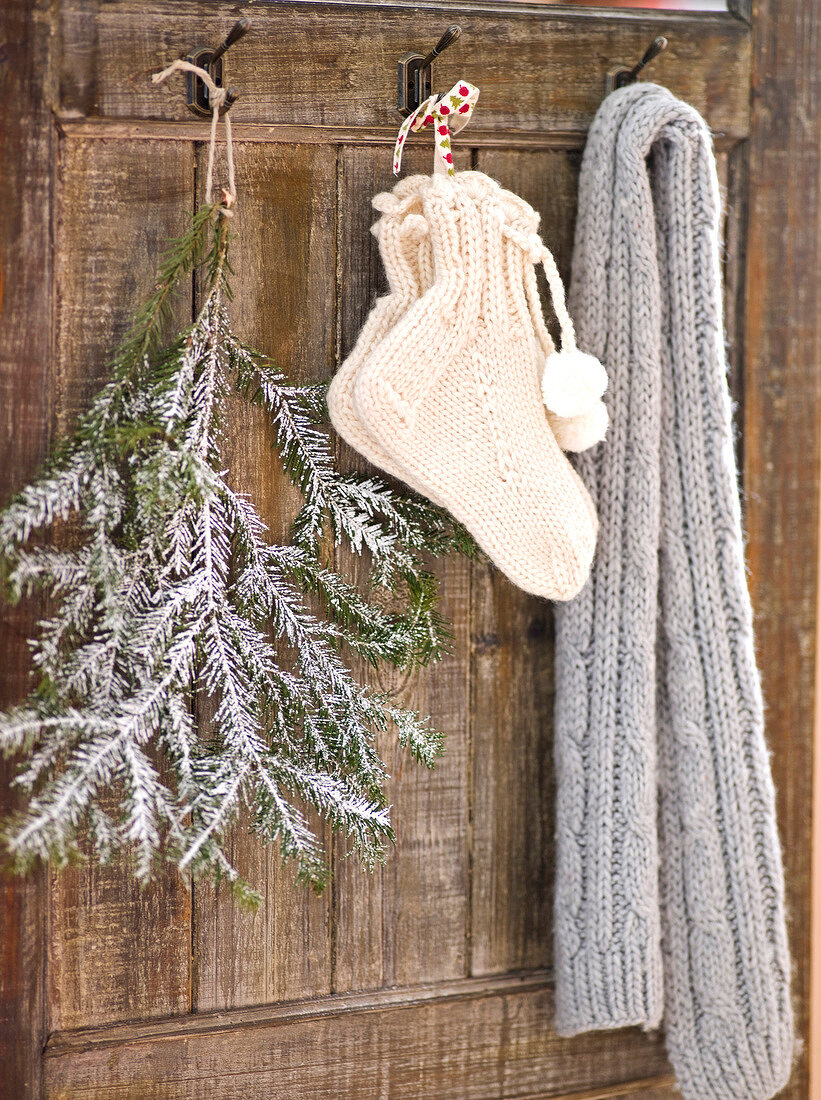 Close-up of branch, socks and scarf hanging on house wall