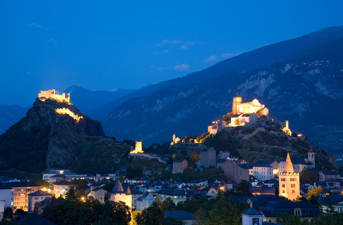 View of cityscape with two castle at dusk in Valais, Switzerland