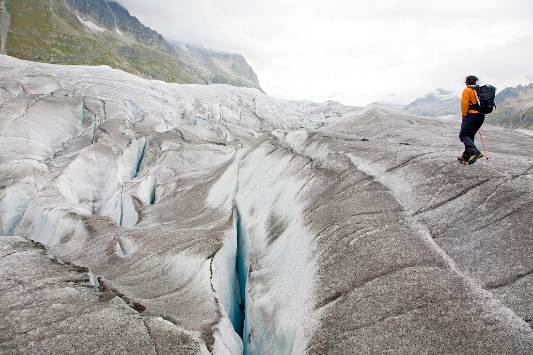 Hiker in front of ice wall in Aletsch Glacier, Marjelesee, Valais, Switzerland