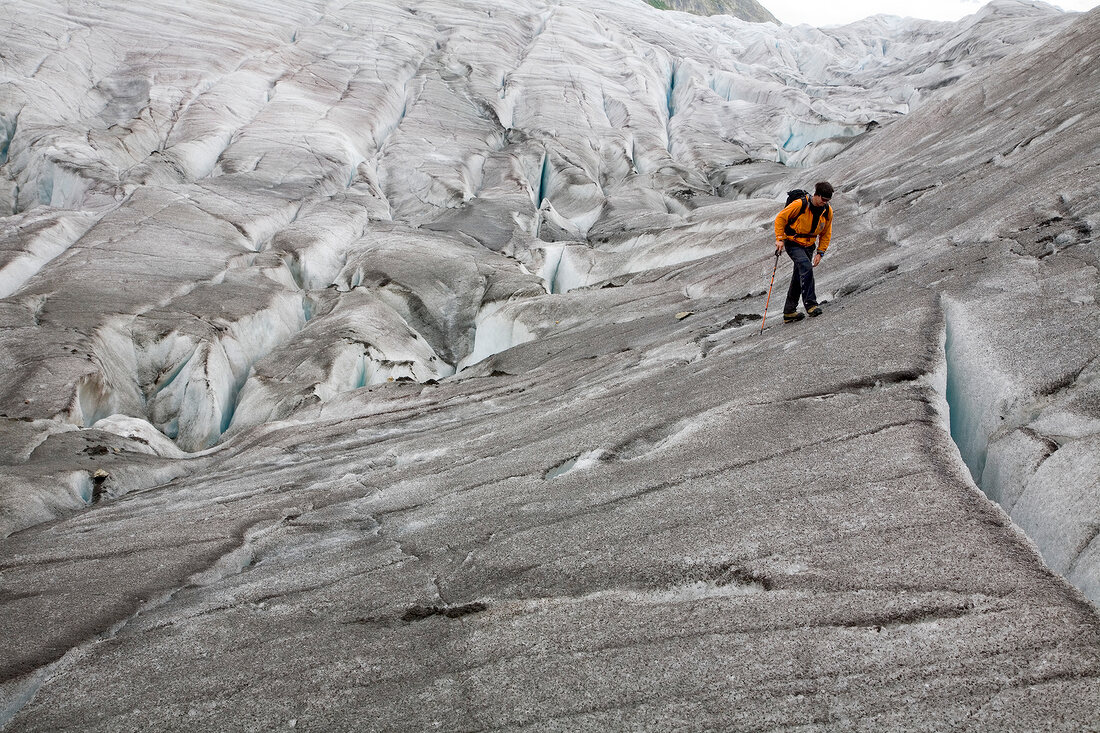 Hiker in front of ice wall in Aletsch Glacier, Marjelesee, Valais, Switzerland
