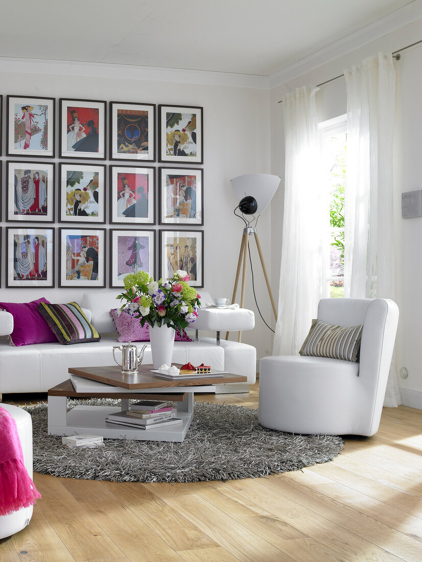 Living room with white sofa and gallery with art deco motifs on wall