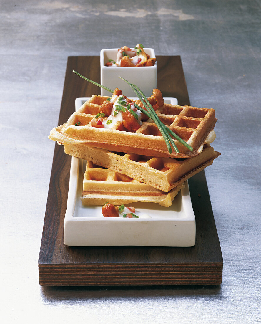 Potato waffles with chanterelles on wooden surface