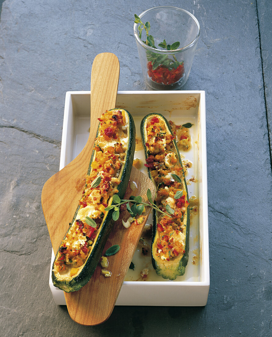 Stuffed zucchini with goat cheese on wooden platter