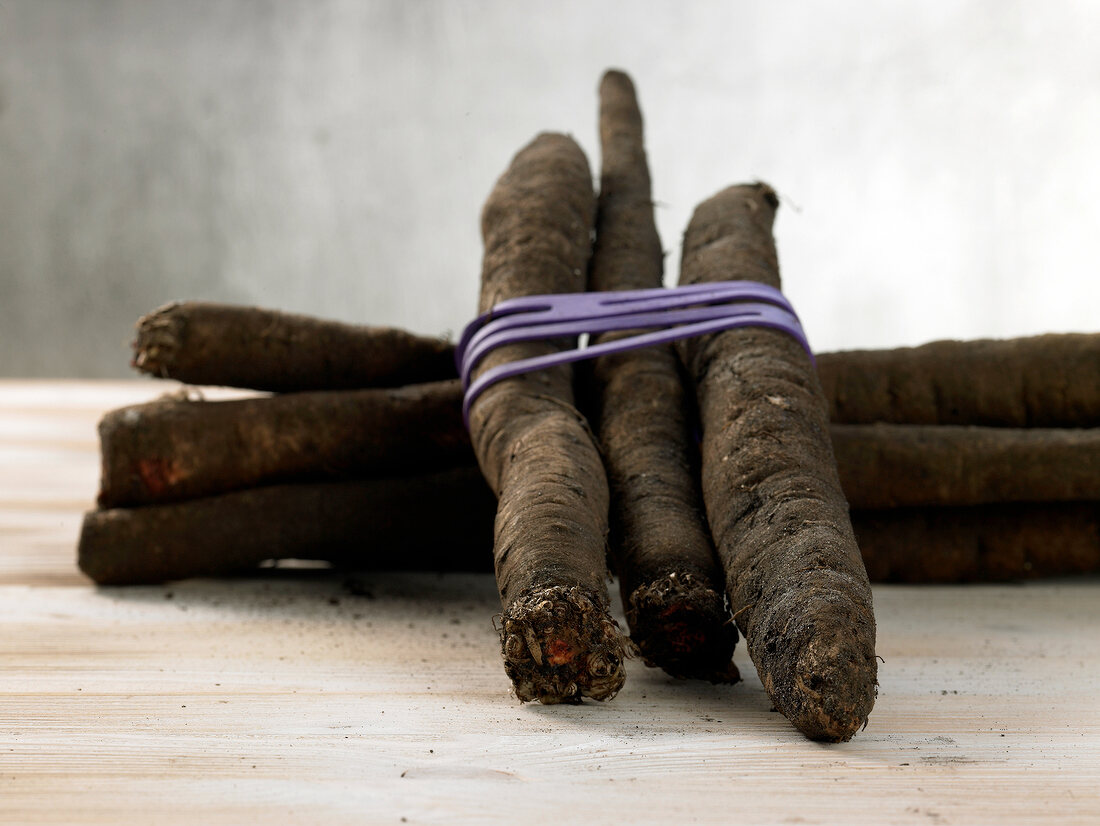 Close-up of salsify tied with string on wooden table
