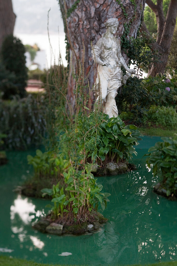 White statue of woman near pond in garden at Costa Brava, Spain