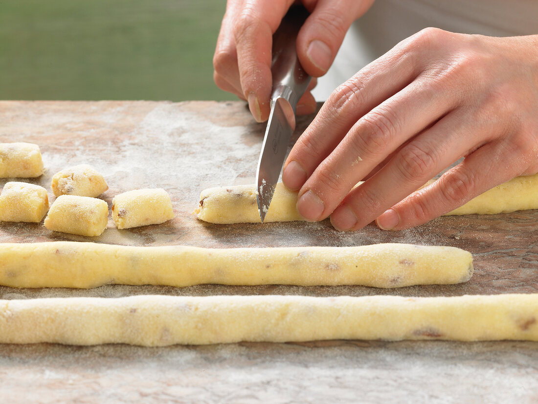 Close-up of hands cutting dough in pieces, step 2