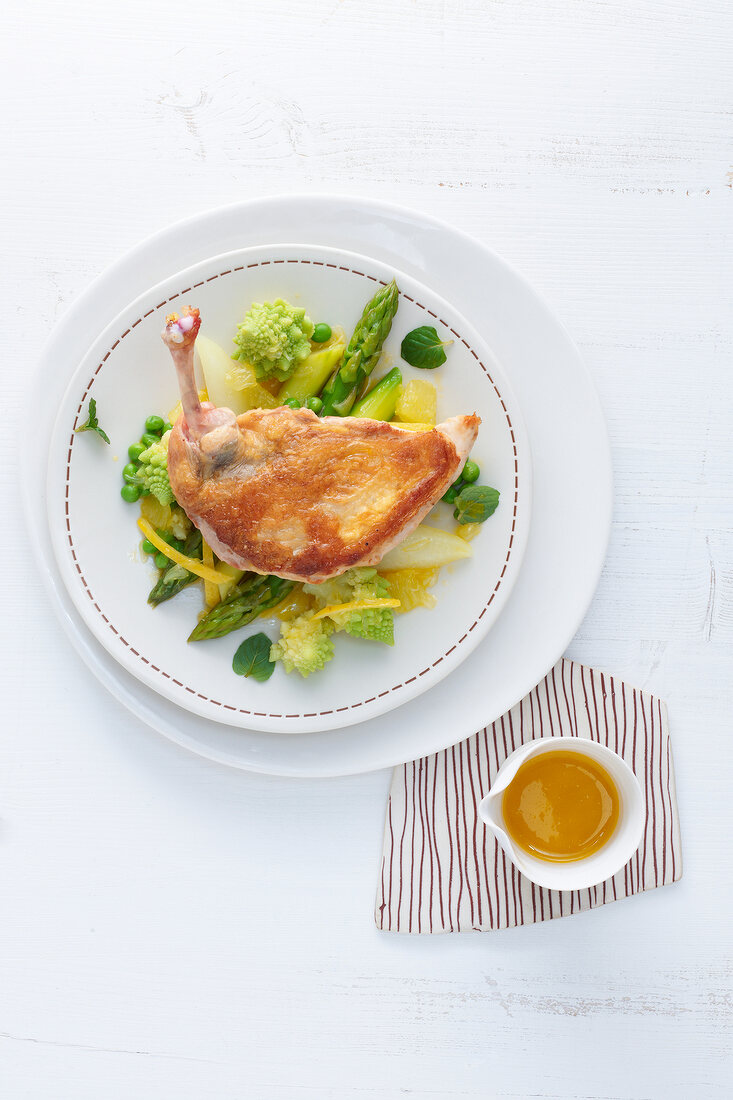 Guinea fowl with vegetables and lemon sauce on plate