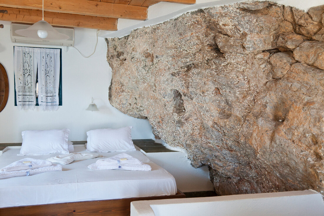 Bedroom with rock wall of Hotel Porto in Loutro, Crete, Greece