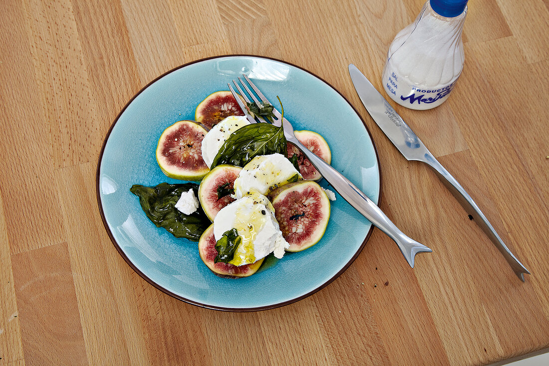Mozzarella with figs and basil on plate