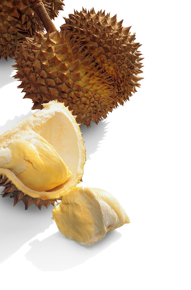 Halved and whole durian on white background