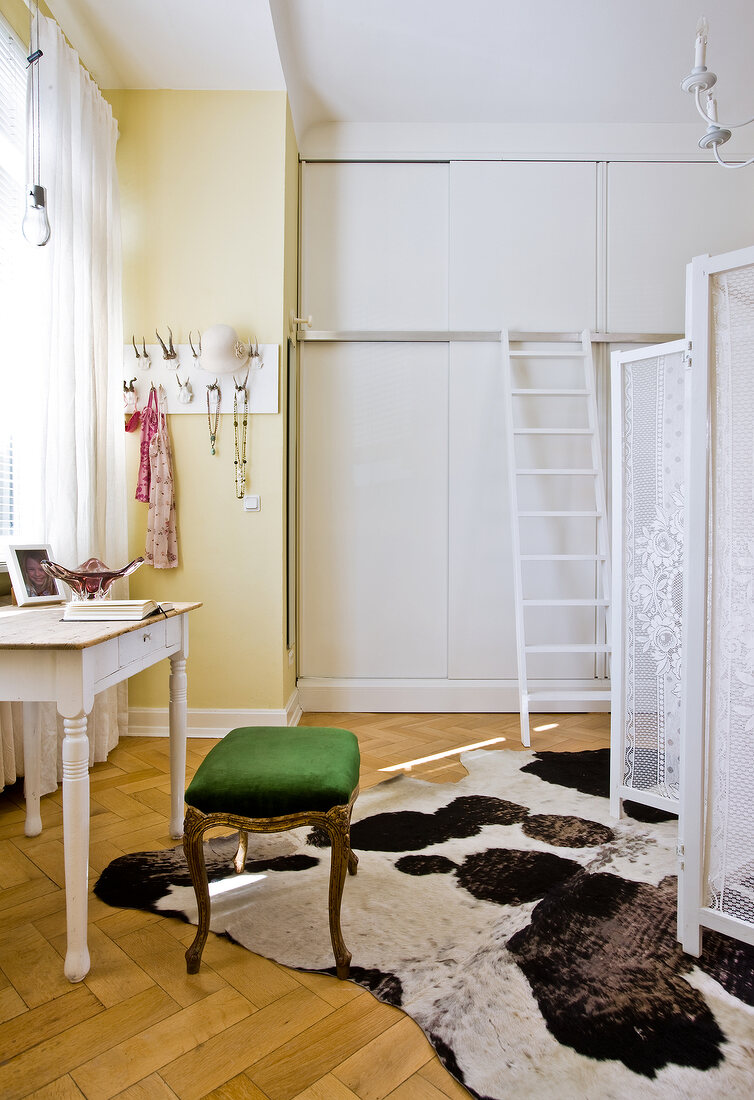 Interior of room with wooden floor, stool and white folding screen in Swedish style