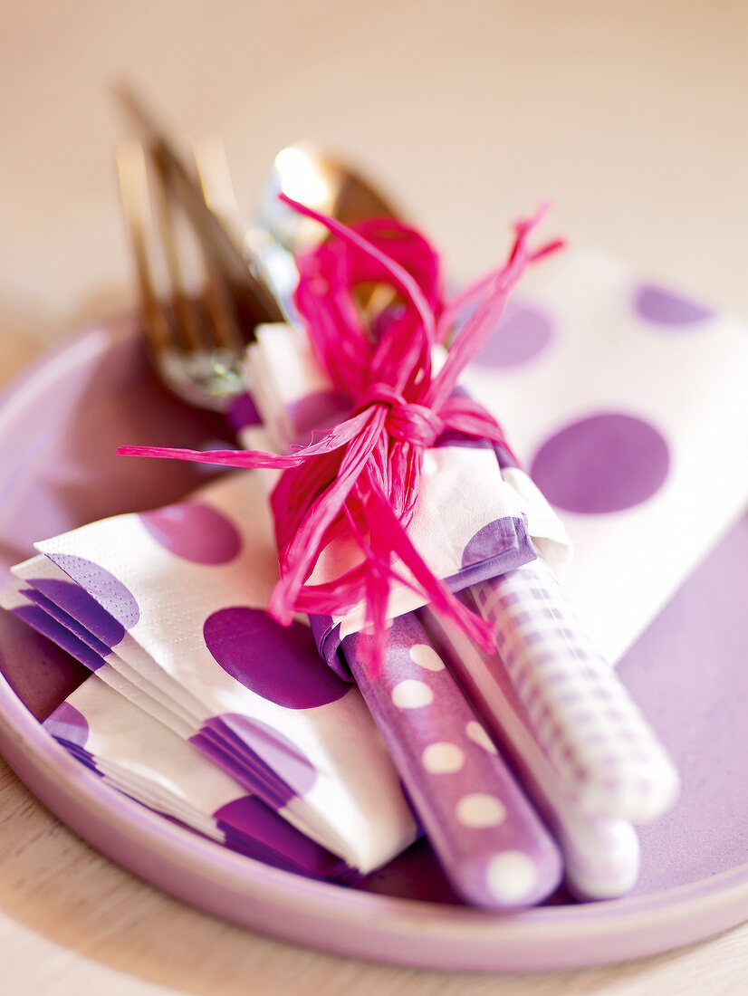 Cutlery wrapped with purple and white napkins