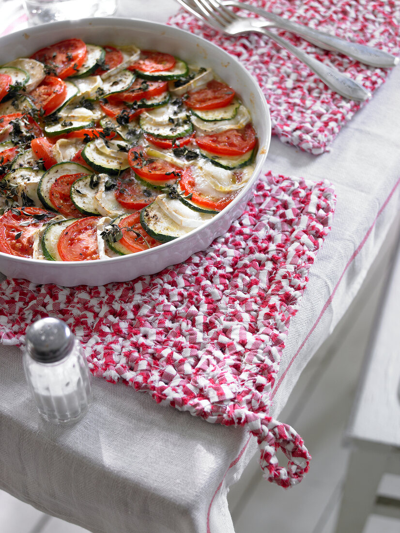 Vegetable tart in pan on red and white crocheted potholders