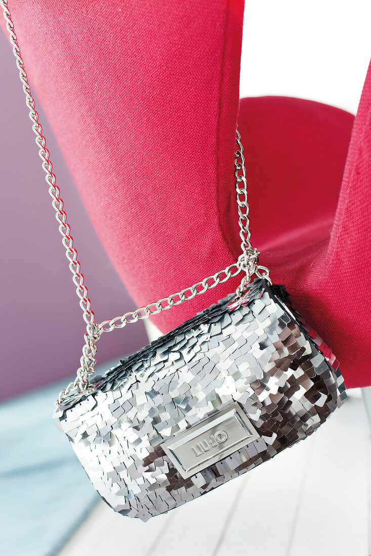Close-up of grey blue sequined evening bag with chains