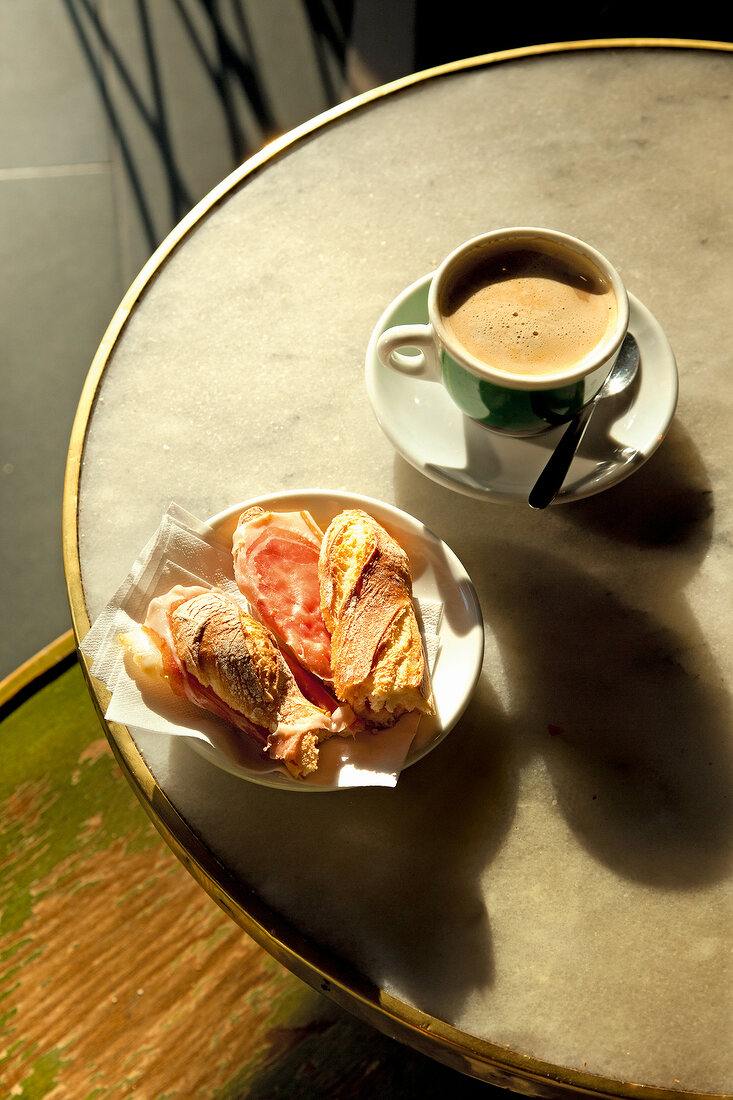 Tisch, Belegtes Brötchen und Tasse Kaffee